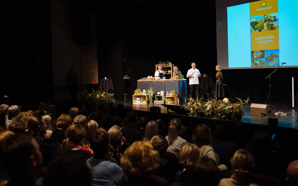 Alain talar på scenen inför publiken.