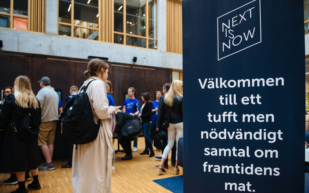 Roll-up med Next is Now-logga och välkomstmeddelande.