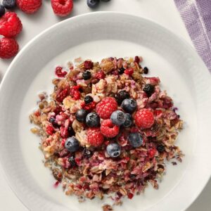 Granola och müsli på en tallrik, med hallon och blåbär.