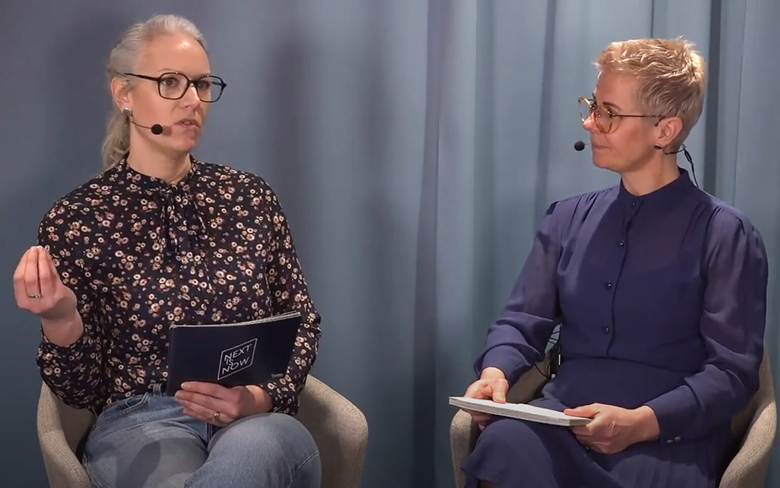 Rebecka Persson och Ann Rebenstam sitter ner och samtalar med talkort i händerna.