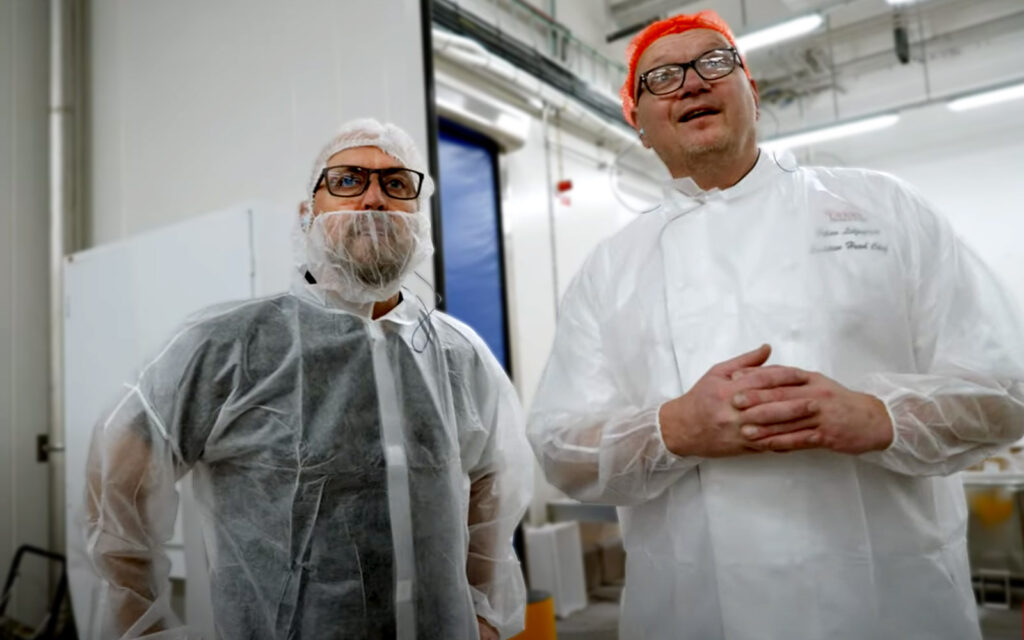 Magnus och Johan står i skyddsdräkter i fabriken i Eslöv, med blickarna riktade över kameran.