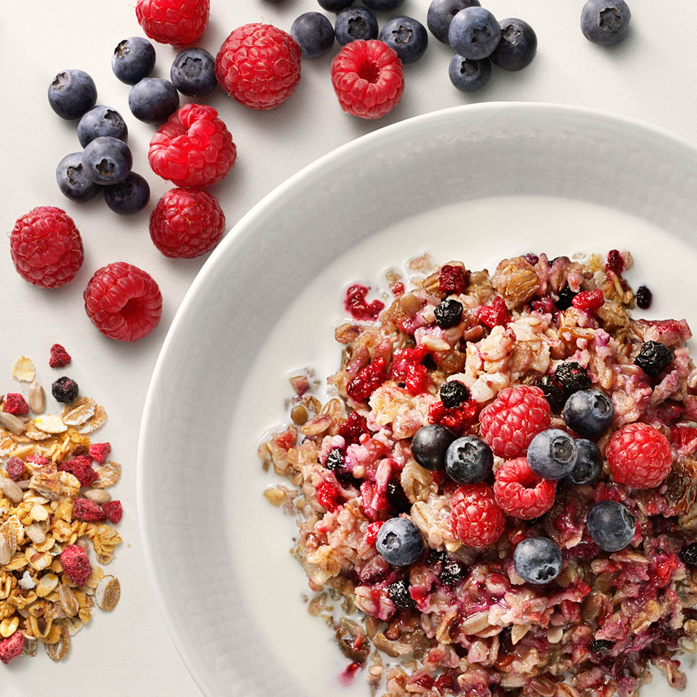 Granola och müsli på en tallrik, med hallon och blåbär.