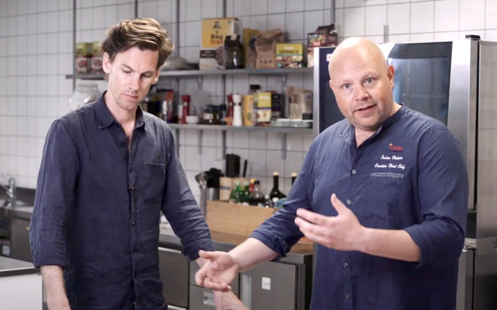 Felix och Johan diskuterar i köket.