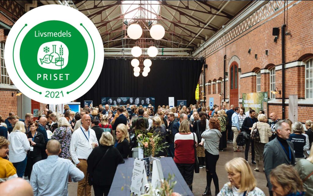 Vy över folk från vårt event Next is Now, med den grön-vita loggan för Livsmedelspriset i ena hörnet.