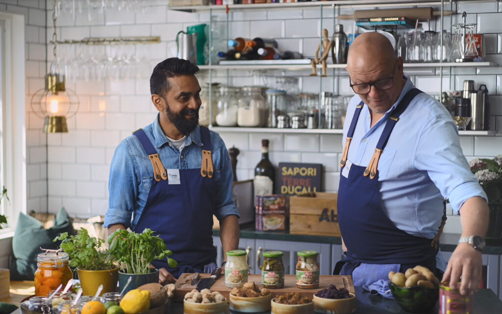 Kockarna Kristoffer och Johan står i köket med tillbehör från Felix framför sig.