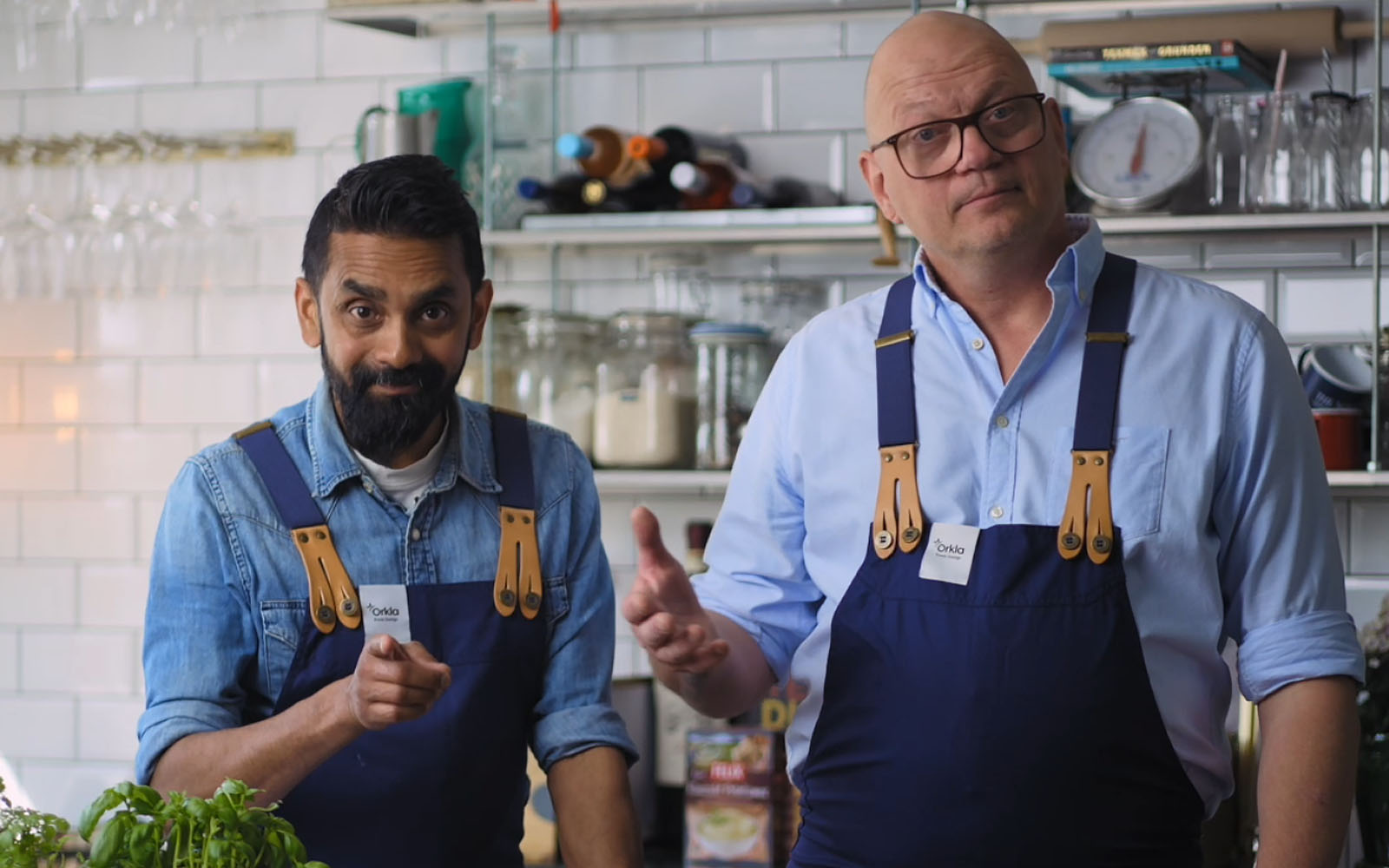 Kockarna Christoffer och Johan står i ett kök. Christoffer pekar mot kameran.