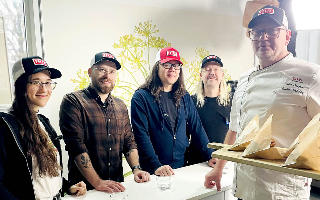 Burgerdudes står bakom jurybord och kocken Johan står med en bricka md burgare i förgrunden.