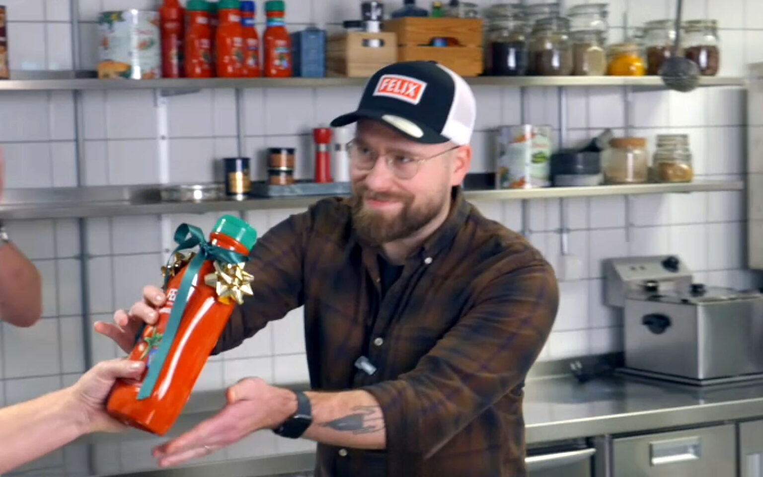 Jurymedlem ur Burgerdudes sträcker fram vinnarpokalen i form av en ketchupflaska från Felix.