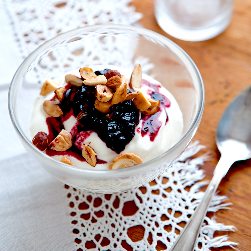 Skål med yoghurt eller kvarg och sylt, toppad med nötter.