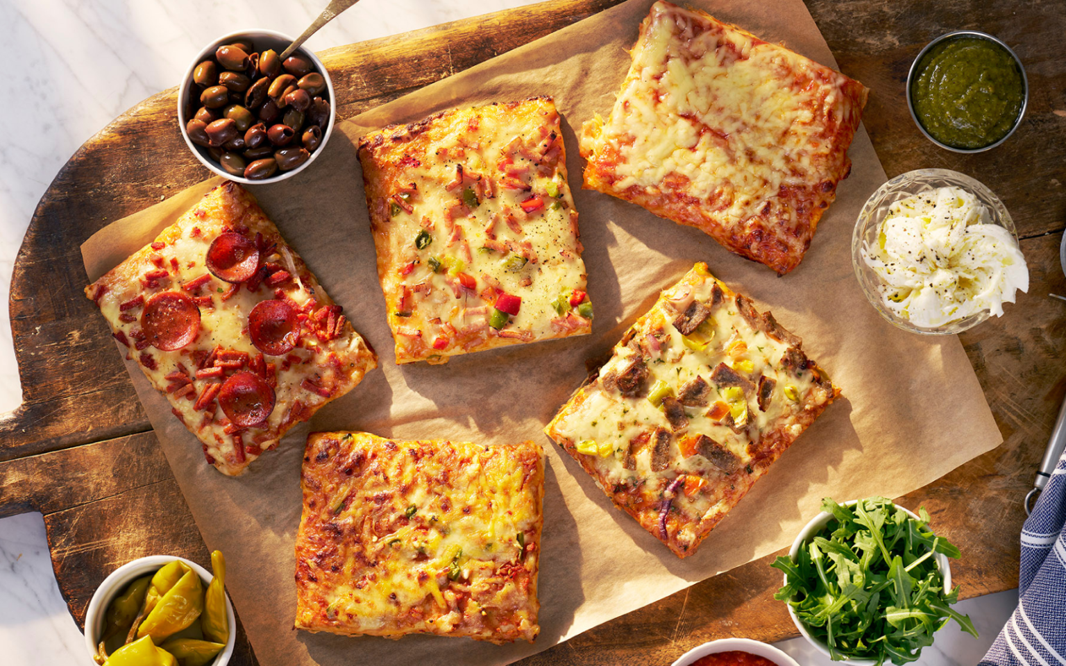 Fyrkantspizza från Orkla FoodSolutions i smakerna Pepperoni, Chili Cheese, Skinka, Kebab och Margherita