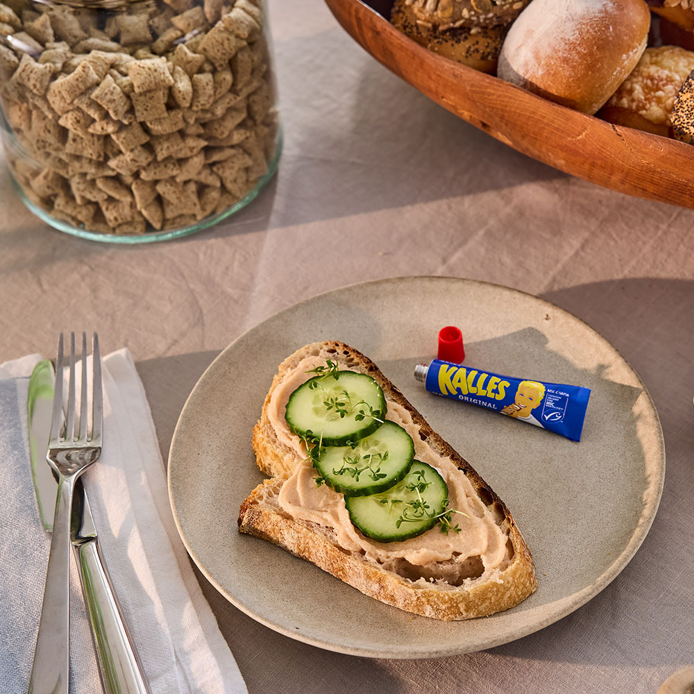 Närbild på kaviarmacka med liten Kalles Kaviar-tub liggande bredvid.