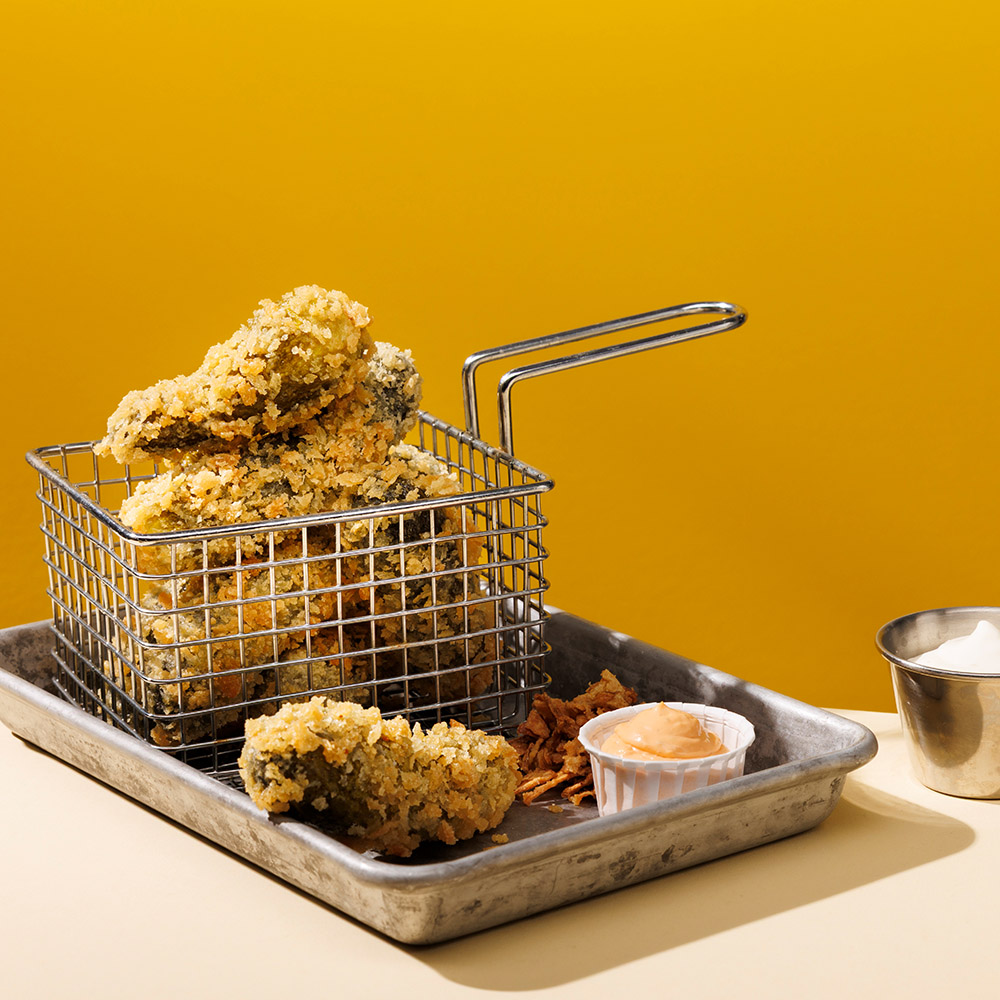 Friterad saltgurka på en bricka med dipsås.